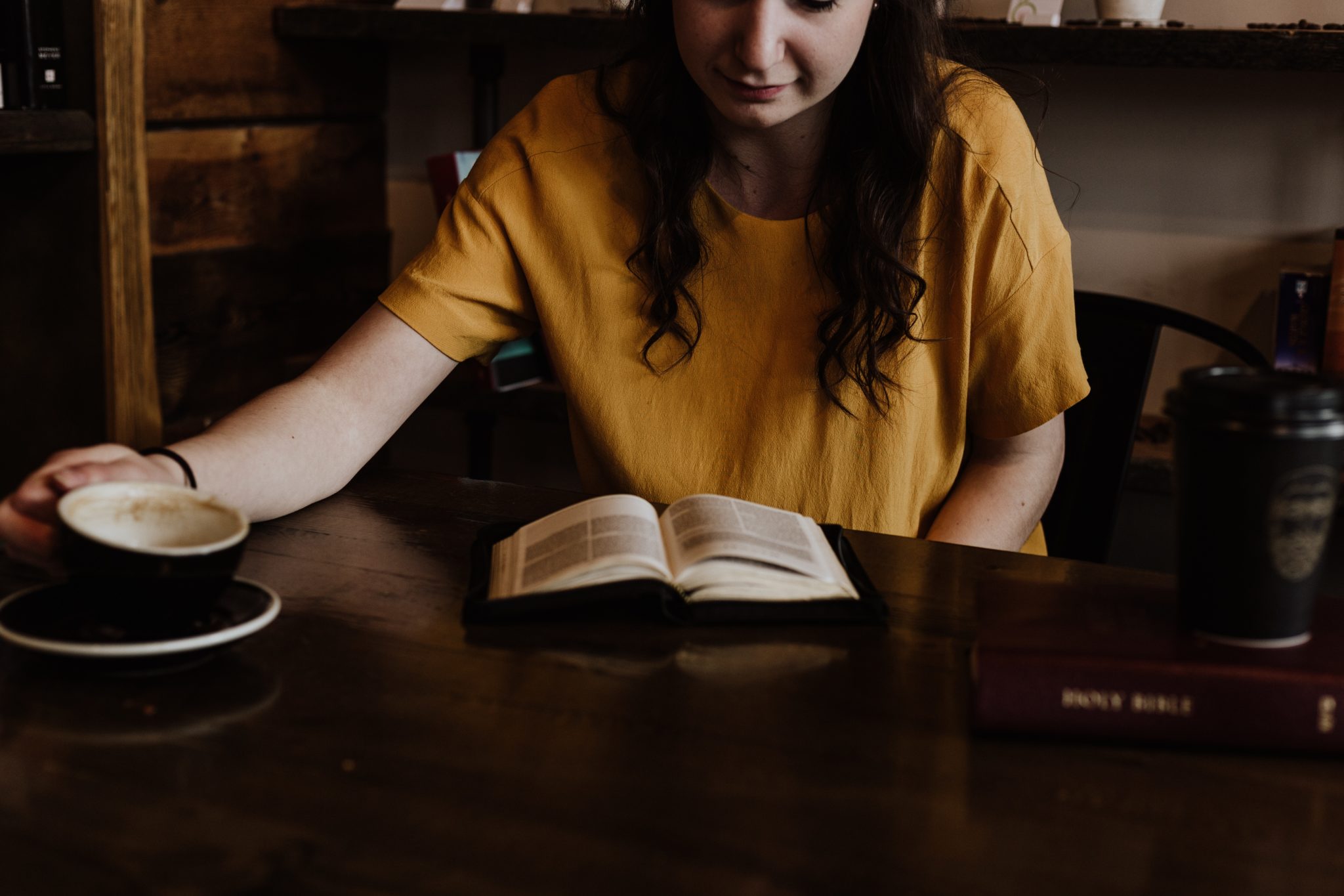 Woman reading bible drinking coffee